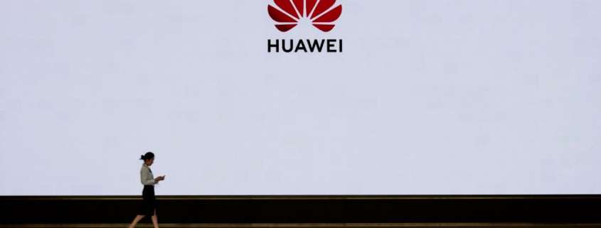 A member of Huawei's reception staff walks in front of a large screen displaying the logo in the foyer of a building used for high profile customer visits and displays at the company's Bantian campus on April 12, 2019 in Shenzhen, China.