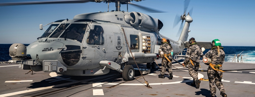 Aviation Technicians from Flight 607 load sonar buoys into the MH-60R-Seahawk helicopter on the flight deck of HMAS Hobart.