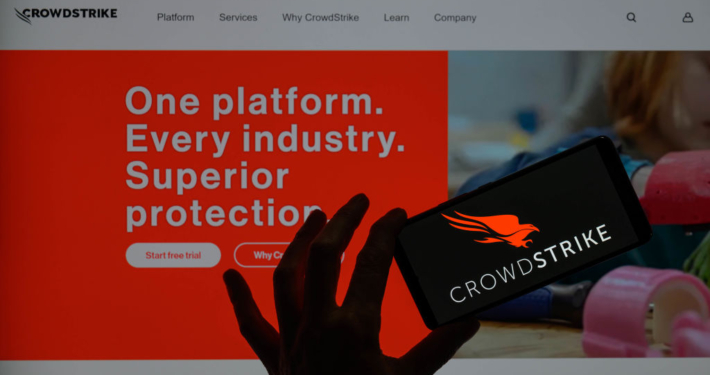 The CrowdStrike logo is being displayed on a smartphone with the CrowdStrike web page visible in the background in this photo illustration in Brussels, Belgium, on July 19, 2024. (Photo Illustration by Jonathan Raa/NurPhoto via Getty Images)