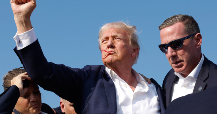 BUTLER, PENNSYLVANIA - JULY 13: Republican presidential candidate former President Donald Trump pumps his fist as he is rushed offstage during a rally on July 13, 2024 in Butler, Pennsylvania. Butler County district attorney Richard Goldinger said the shooter is dead after injuring former U.S. President Donald Trump, killing one audience member and injuring another in the shooting. (Photo by Anna Moneymaker/Getty Images)