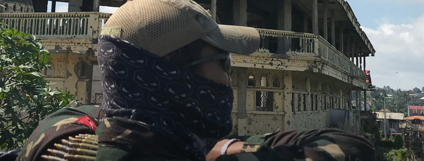 A member of the Armed Forces of the Philippines looks out over the remains of Marawi, with the Great Mosque ahead, 11 October 2018. Photo: Katja Theodorakis.